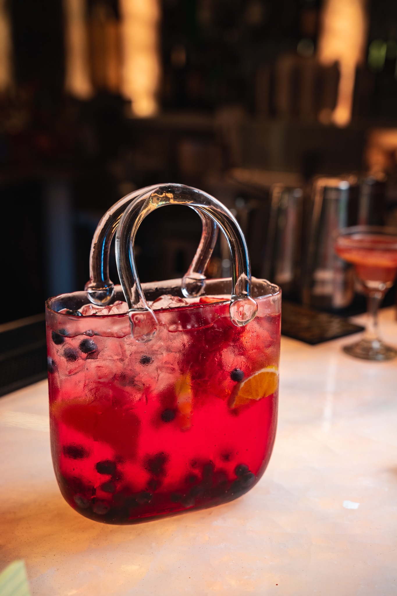 The Mango Yard's berry-red shareable LV cocktail in a glass handbag